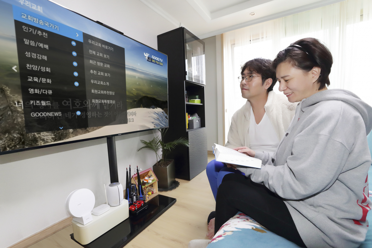 KT 모델들이 올레 tv를 통해 종교활동을 할 수 있는 ‘우리교회tv’ 서비스를 이용하고 있다. [KT 제공]