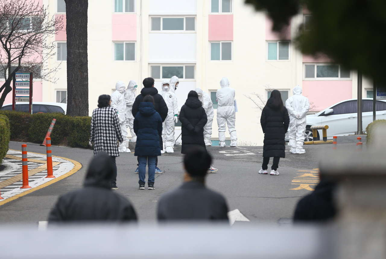 신종 코로나바이러스 감염증(코로나19) 집단 확진이 나온 대구시 달서구 한마음 아파트에서 8일 오전 확진 주민의 생활치료센터 이송을 위해 의료진과 대구시 관계자들이 확진 주민을 기다리고 있다. 연합뉴스