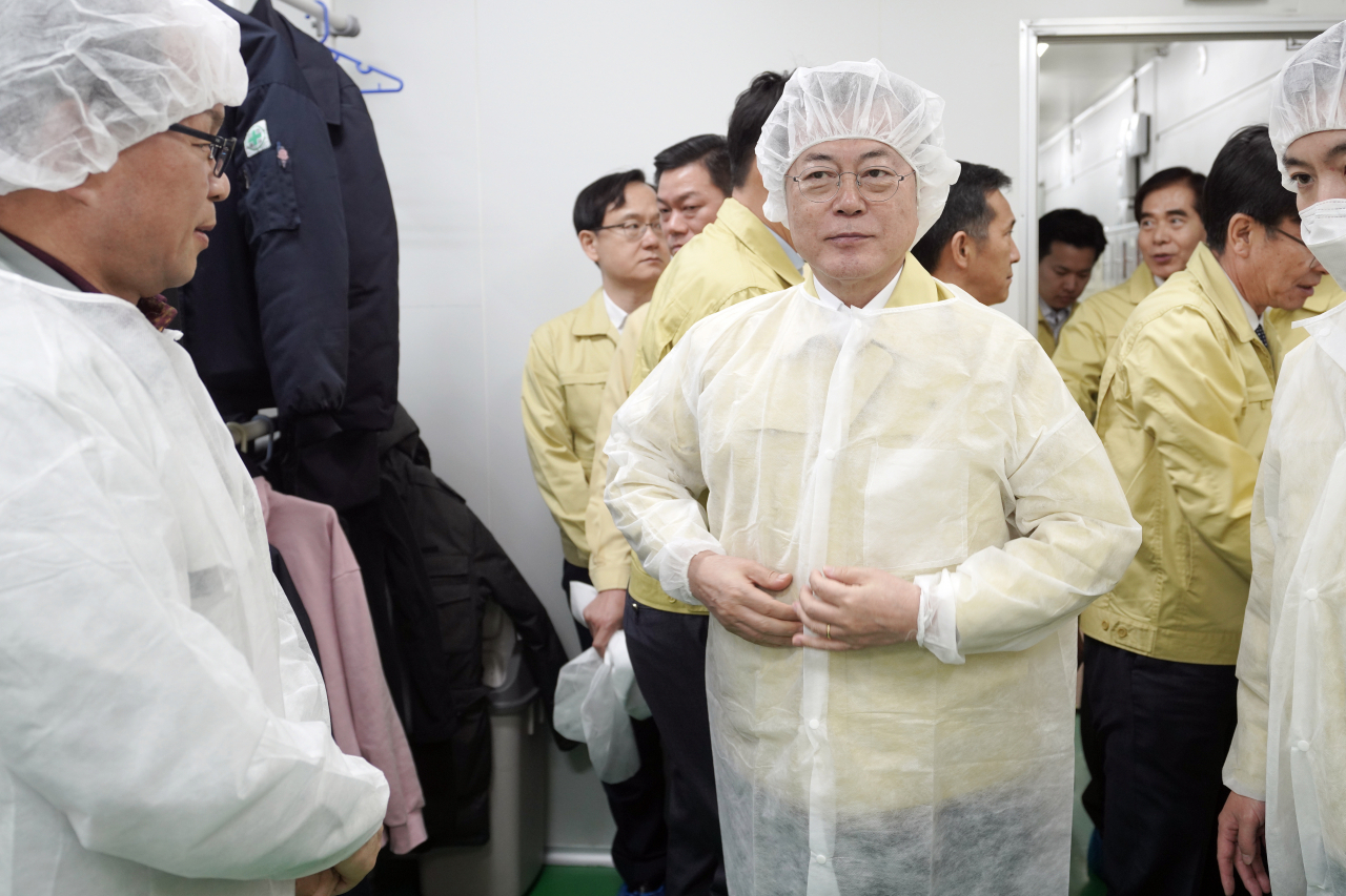 문재인 대통령이 지난 6일 마스크 생산업체인 경기도 평택시 ㈜우일씨앤텍을 방문, 생산 공정을 둘러보기에 앞서 위생복을 착용하고 있다. [연합]