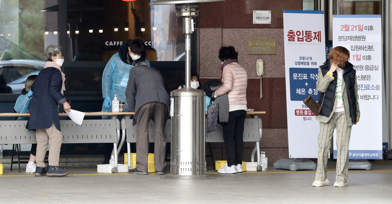 9일 오후 경기도 성남 분당서울대병원 1동 건물을 찾은 방문객들이 방문자 문진표를 작성하고 있다. 분당서울대병원은 통증센터 안내직 직원이 코로나19 확진 판정을 받은 것과 관련해 이날 오전 1동 지하 2층 통증센터를 폐쇄했다. 연합뉴스