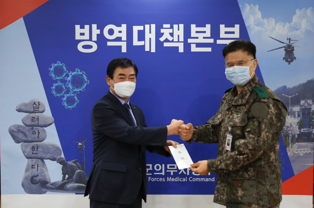 김도호 군인공제회 이사장(왼쪽)이 9일 국군의무사령부를 방문하여,코로나19 차단을 위해 헌신하고 있는 장병들을 위한 위문금을 전달하고 있다. [군인공제회 제공]
