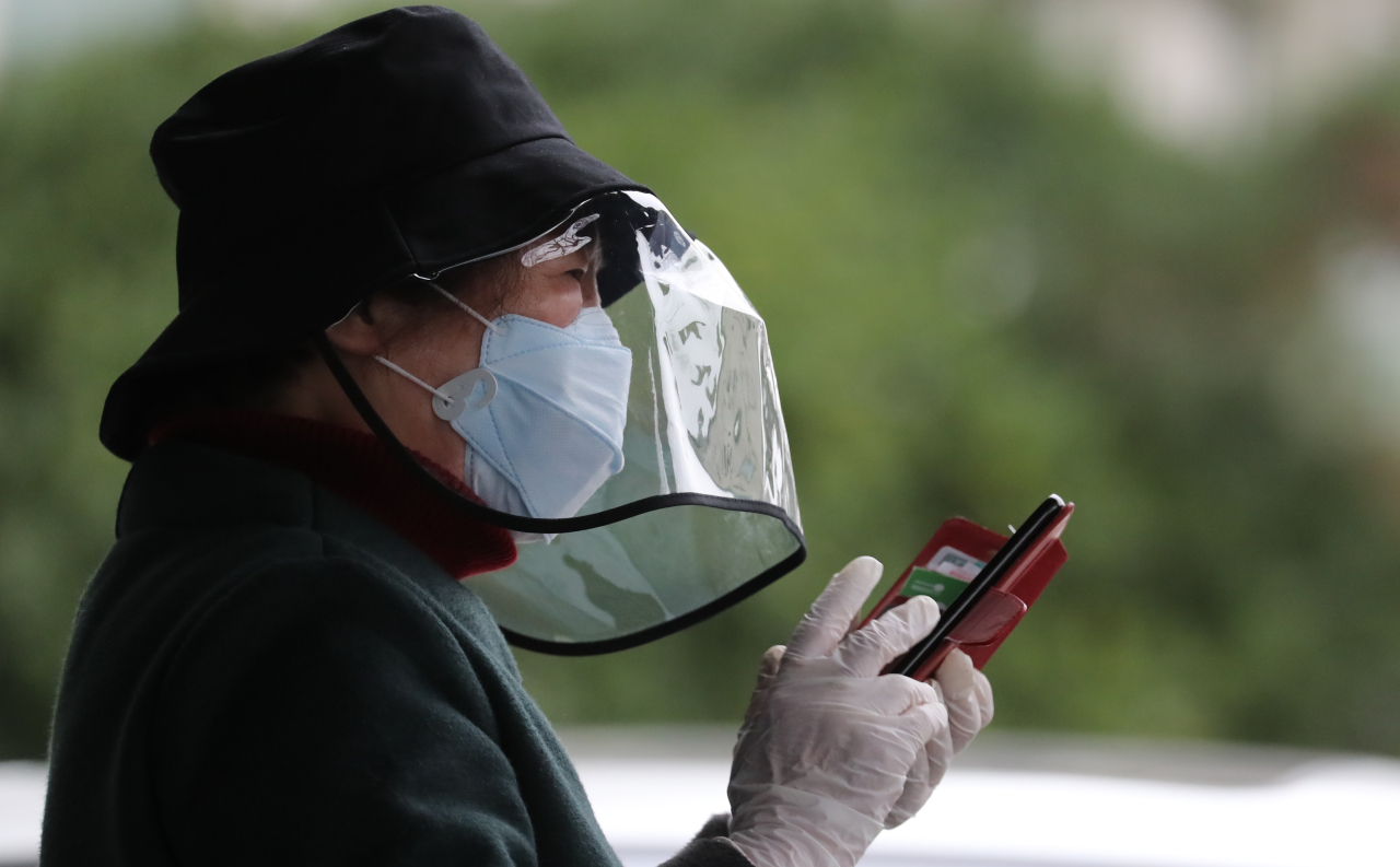 A woman in full protective gear photographed Monday near a hospital in Daegu, South Korea's worst-affected city. (Yonhap)