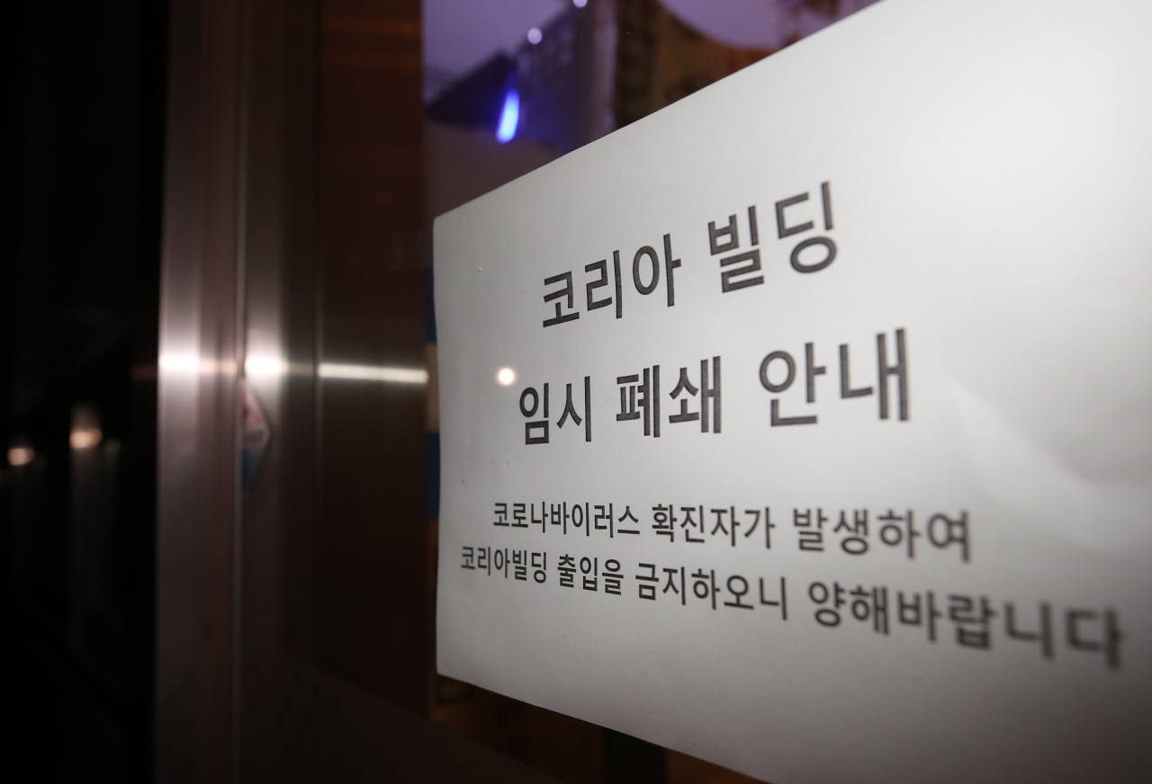 서울 구로구 신도림동 코리아빌딩 11층에 있는 콜센터에서 집단 감염 사례로 추정되는 코로나19 확진자가 무더기로 발생했다고 구로구가 밝힌 9일 해당 건물 앞에 임시 폐쇄 관련 안내문이 붙어 있다. [연합]