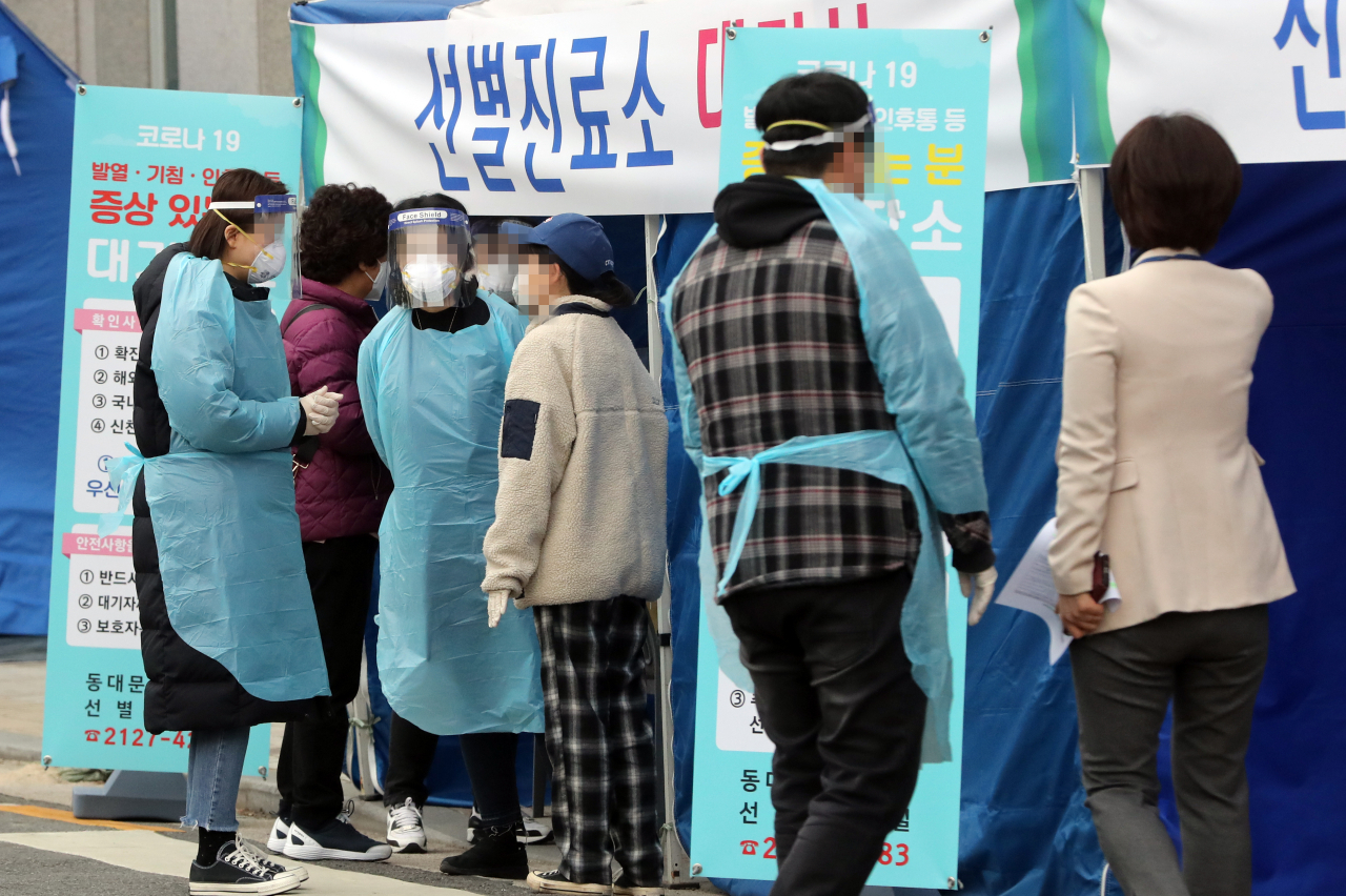 9일 서울 동대문구 보건소에서 관계자들이 선별진료소를 찾은 시민을 안내하고 있다. [연합]