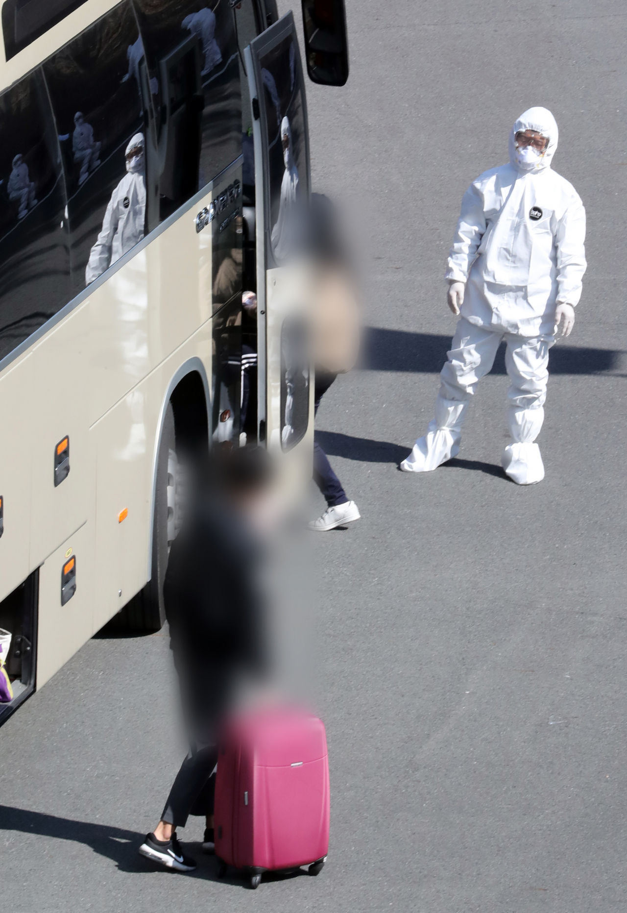지난 6일 오후 대구시 수성구 노변동 대구스타디움에 집결한 신종 코로나바이러스 감염증(코로나19) 경증 확진환자들이 각 지역에 마련된 생활치료센터로 향하는 버스에 오르고 있다. [연합]