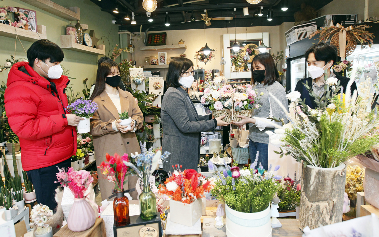 동작구 직원들이 花요일을 맞아 사당동 화훼업소에서 꽃과 화분을 구입하고 있다. [동작구 제공]