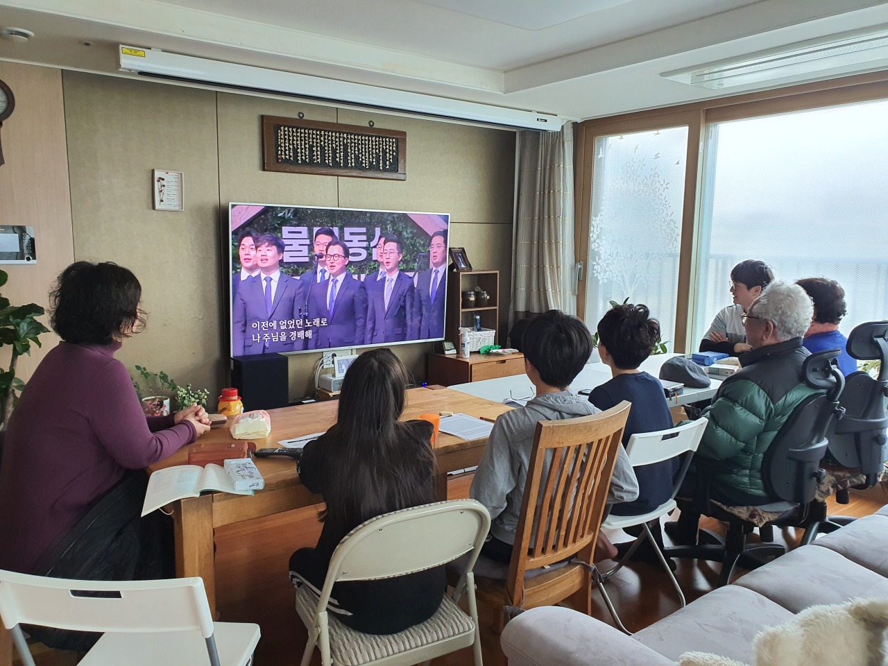 Family gathers in a living room on Sunday for the online Sunday service. (Sarang Church)