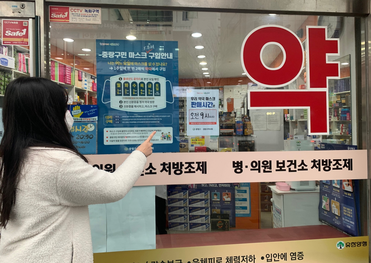 한 주민이 중랑구 자체 제작 마스크 5부제 구입안내 포스터를 확인하고 있는 모습. [중랑구 제공]
