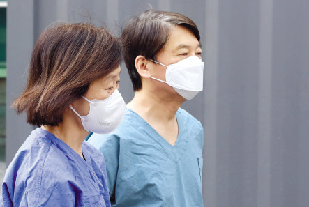 안철수 국민의당 대표(오른쪽)와 부인 김미경 교수가 9일 오전 대구시 신종 코로나바이러스 감염증(코로나19) 지역거점병원인 계명대학교 대구동산병원에서 진료 자원봉사를 하기 위해 보호구 착의실로 가고 있다. [연합]