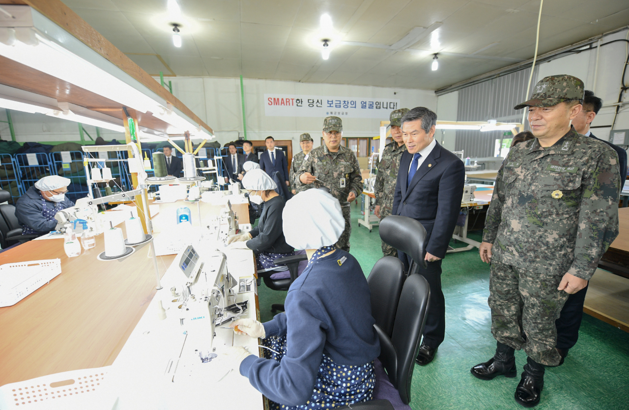 정경두 장관이 경남 진해 소재 해군 보급창을 방문해 면 마스크를 생산하는 장병 및 군무원들을 격려하고 있다.[연합]