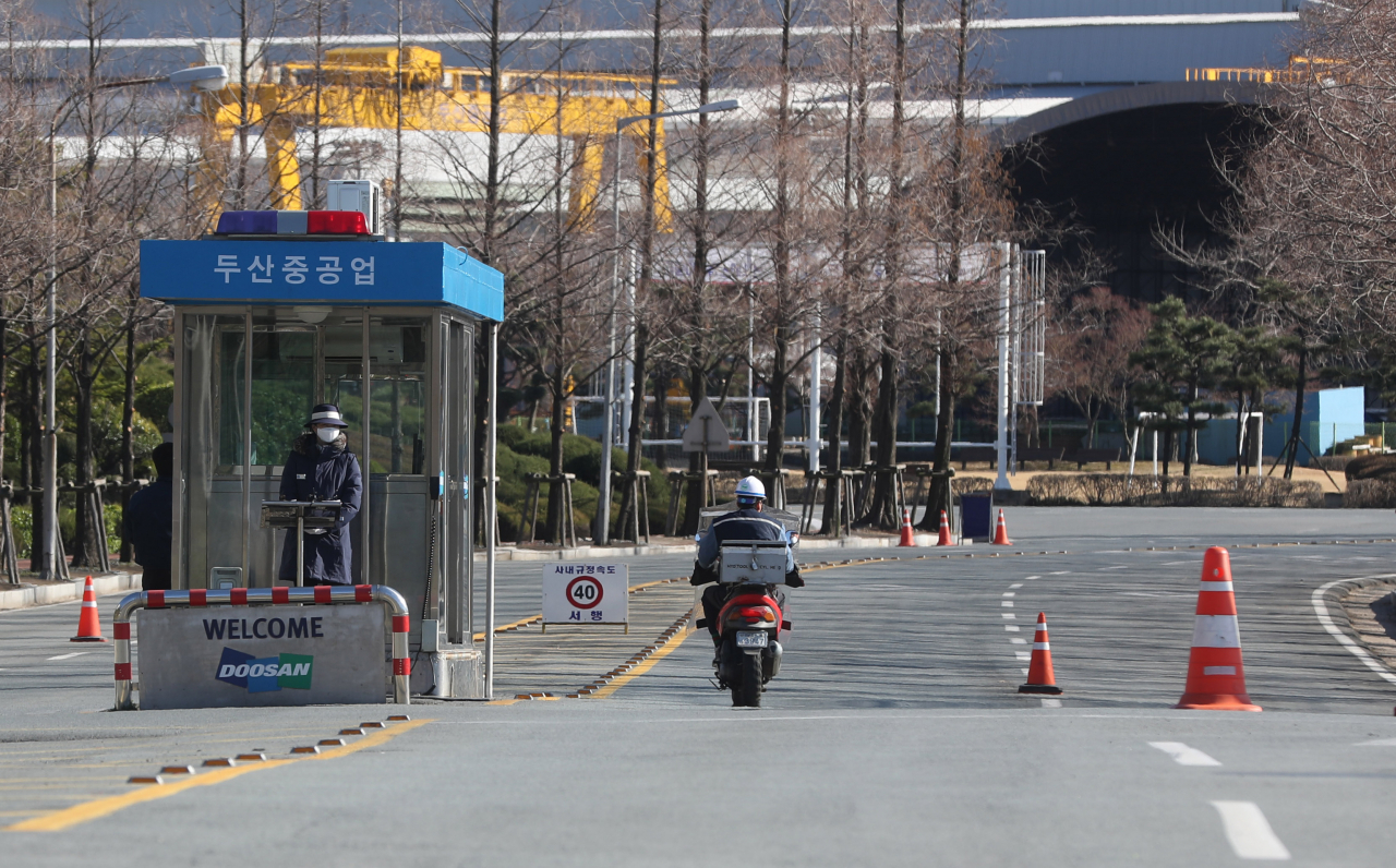 수주 부진으로 경영 위기를 겪는 두산중공업이 명예퇴직에 이어 휴업까지 검토하고 있다. 사진은 11일 오후 경남 창원시 성산구 두산중공업 정문 안으로 오토바이가 들어가는 모습. [연합]