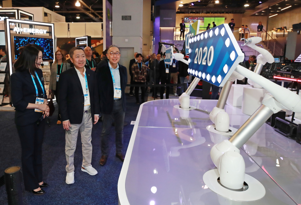 세계 최대 가전·정보기술(IT) 전시회 CES(Consumer Electronics Show) 2020가 열린 지난 1월 8일(현지시간) 미국 네바다주 라스베이거스 컨벤션센터 두산 부스에서 박정원 두산그룹 회장(가운데)과 박지원 두산중공업 회장(오른쪽)이 협동로봇을 살피고 있다. [연합]