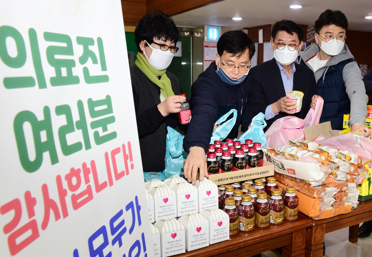 최수아 행궁동 주민자치회 부회장(왼쪽부터), 민효근 행궁동장, 한창석 행궁동 주민자치회 회장 등이 10일 간식을 나눠 담고 있다. [수원시 제공]