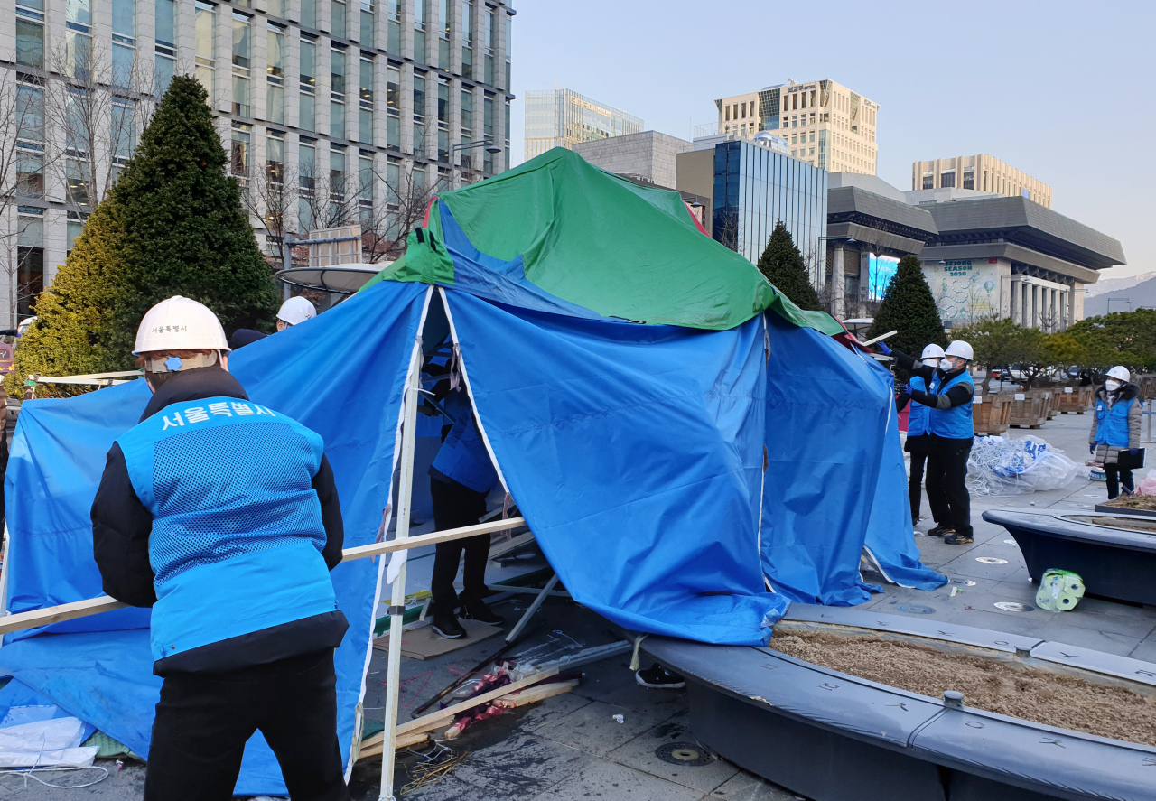 12일 오전 서울시청 관계자들이 서울 종로구 광화문광장에서 시민단체 전두환심판국민행동이 설치한 천막 한 개 동을 철거하는 행정대집행을 하고 있다. [연합]