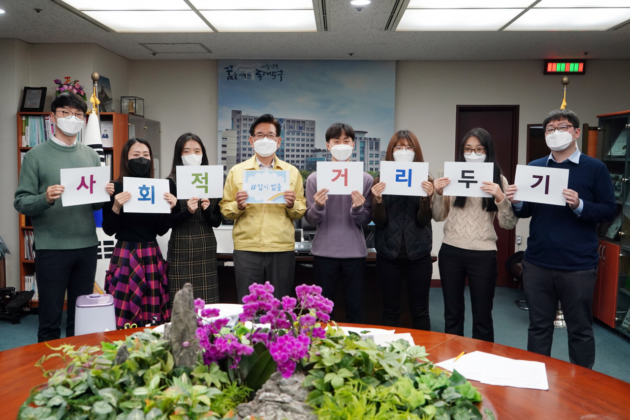 유덕열(왼쪽 네번째) 동대문구청장이 직원들과 함께 사회적 거리두기 ‘잠시 멈춤’ 캠페인을 위해 홍보 영상 제작에 동참했다. [동대문구 제공]