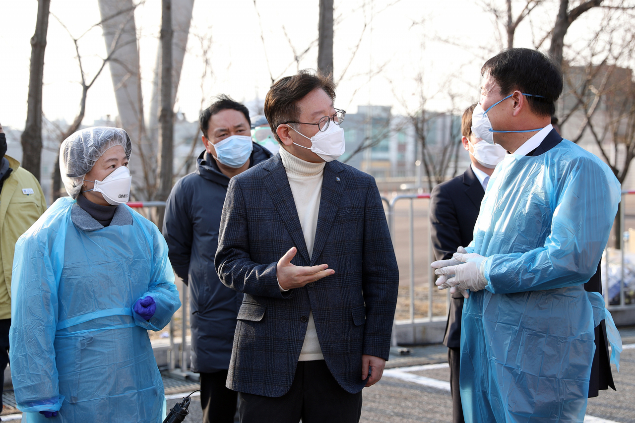 7일 오후 이재명 경기도지사가 수원월드컵경기장 드라이브 스루 코로나19 선별검사센터를 방문해 관계자들과 함께 현장을 살펴보며 이야기를 하고 있다. 연합뉴스