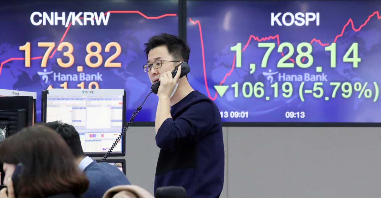 13일 서울 을지로 하나은행 본점 딜링룸에서 외환딜러들이 업무를 보고 있다. 이날 코스피는 유럽과 미국 증시가 10% 안팎 무너지는 등 글로벌 증시의 '대폭락 장세'가 이어지며 장중 1,700선이 붕괴됐다. 연합뉴스