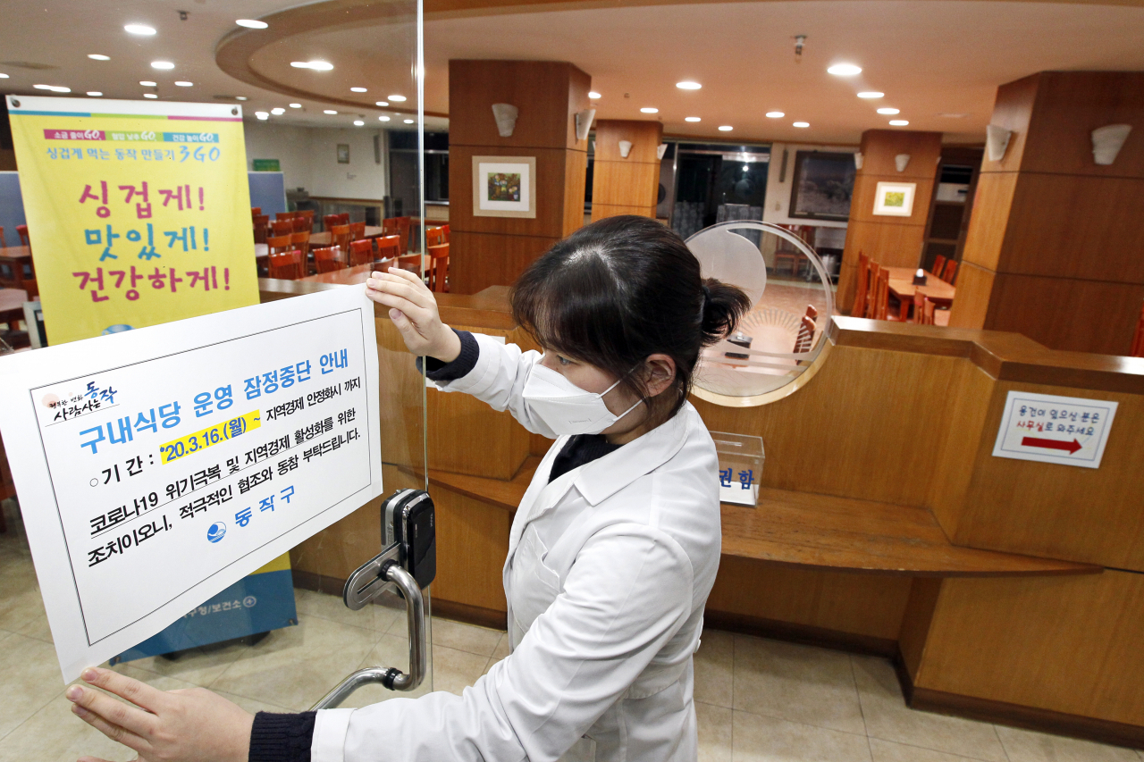 동작구청 구내식당 영양사가 잠정중단 안내문을 부착하고 있다. [동작구 제공]