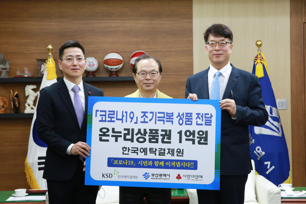 한국예탁결제원은 13일 코로나19 확산으로 어려움을 겪는 부산지역 내 소상공인과 취약계층을 지원하기 위해 1억원 상당의 온누리상품권을 부산시에 전달했다. 사진은 이날 전달식이 끝나고 기념사진을 촬영하는 이명호 예탁결제원 사장(오른쪽), 오거돈 부산시장(가운데), 박은덕 부산사회복지공동모금회 사무처장의 모습. [한국예탁결제원 제공]
