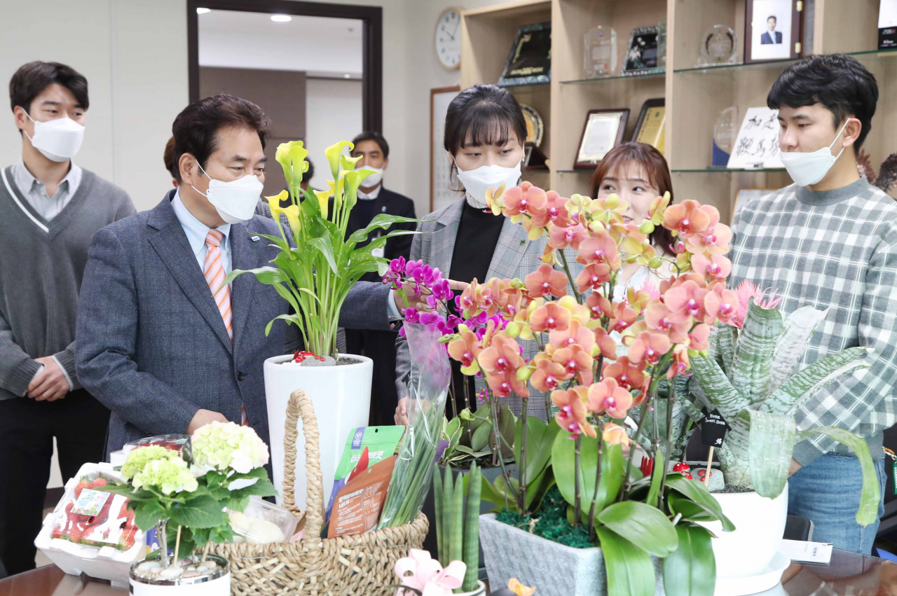 백군기 용인시장이 청년 농업인들로부터 생산화훼에 대한 설명을 듣고 있다. [용인시 제공]