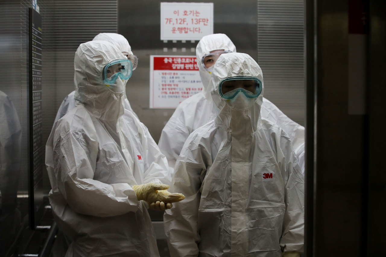 Medical staff dressed in protetive gear head to a ward where COVID-19 patients are in isolation at a hospital in Seoul. Yonhap