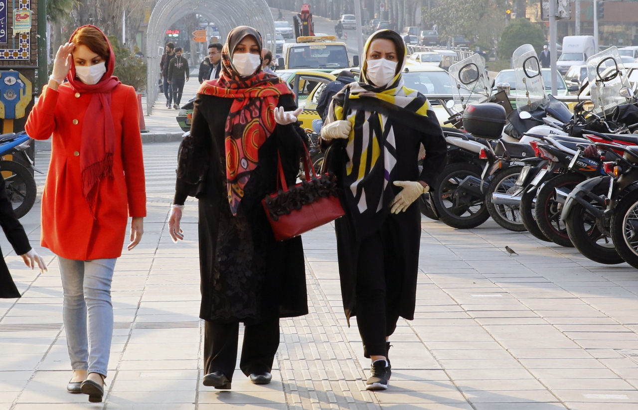 Iranians wearing face masks and protective gloves go shopping in a bazaar during the coronavirus pandemic in Tehran, Iran, March 12. (EPA-Yonhap)