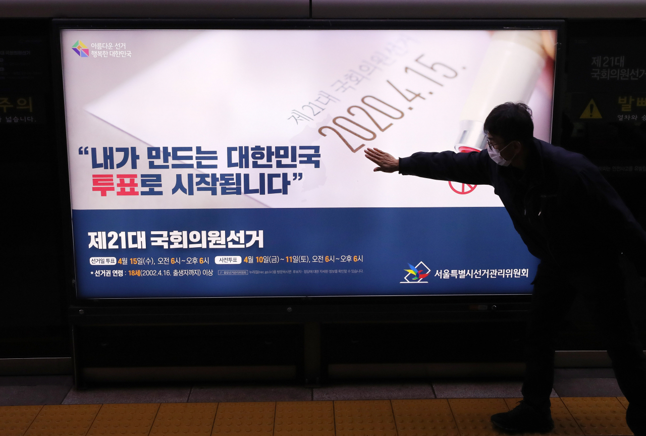 13일 오후 서울 지하철3호선 충무로역 승강장에 서울시선관위 관계자들이 총선 관련 홍보물을 붙이고 있다.[연합]