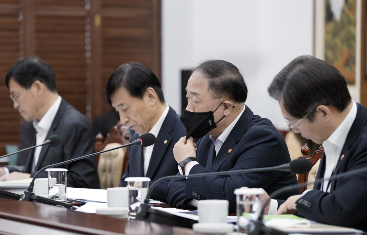 BOK Gov. Lee Ju Yeol (center left) and Finance Minister Hong Nam-ki (center right) wearing a face mask briefs President Moon Jae-in at Cheong Wa Dae on March 13, 2020. (Yonhap)