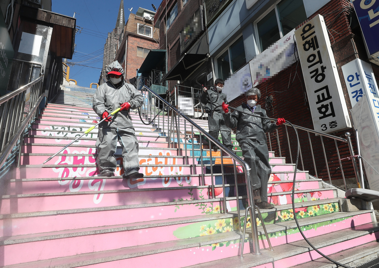 Sujeong-gu environmental sanitation department officials sanitize the area near Grace River Church in Seongnam, Gyeonggi Province, on Monday. (Yonhap)