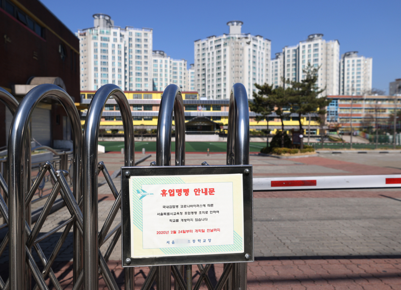 전국 유치원과 초·중·고등학교 개학 연기를 둘러싼 논의가 진행 중인 가운데 16일 서울 성북구 한 초등학교 정문에 휴업 안내문이 세워져 있다. [연합]