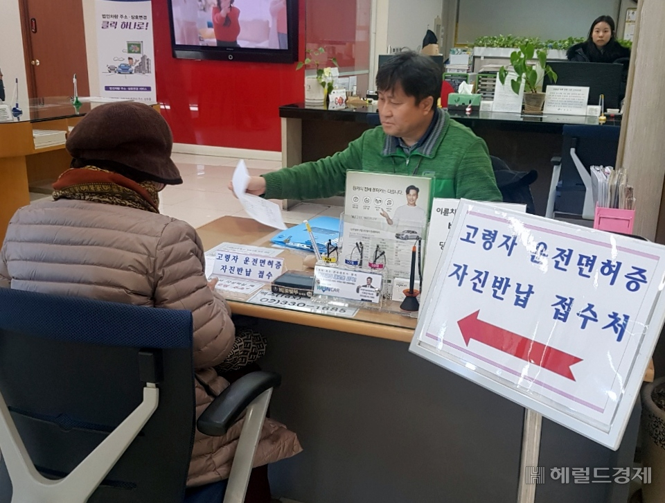 한 어르신이 운전면허 반납하고 있다.