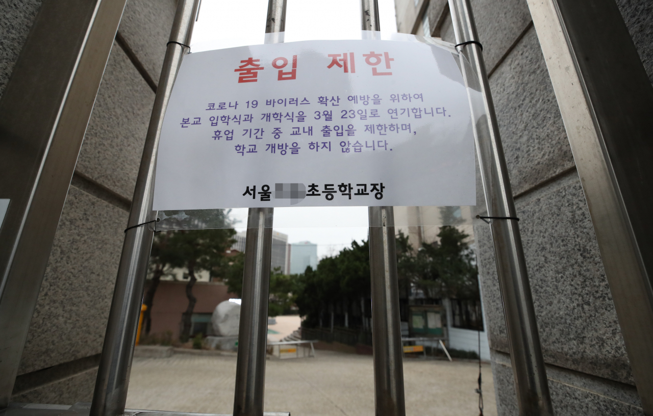 신종 코로나바이러스 감염증(코로나19) 여파로 전국 유치원과 초·중·고등학교 개학이 2주일 더 연기된 17일 서울의 한 초등학교에 출입 제한 안내문이 붙어있다. [연합]