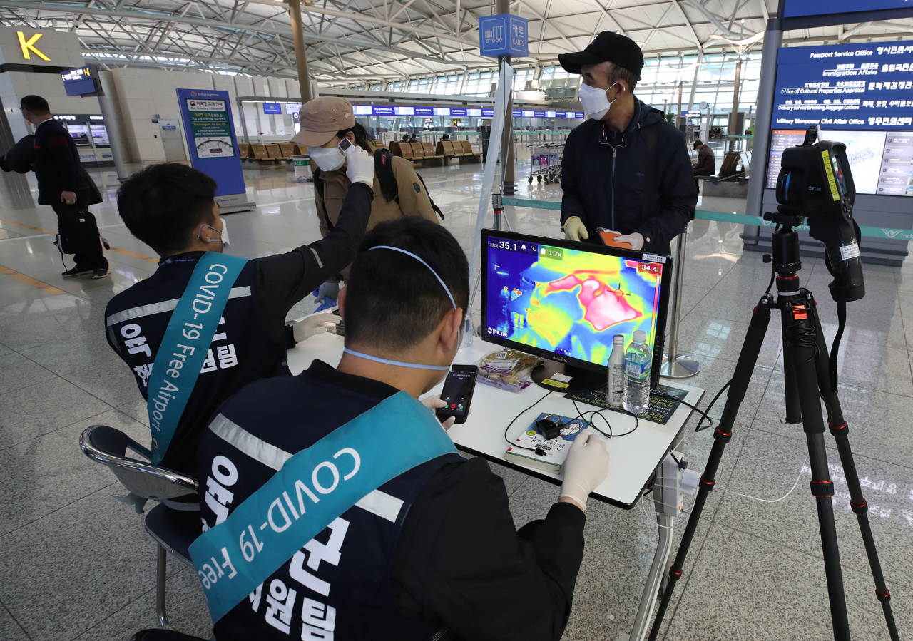 인천국제공항 1터미널 2단계 발열체크 현장에서 육군 현장지원팀이 출국자들의 체온을 측정하고 있다.[연합]