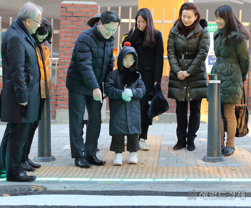 채현일 영등포구청장이 여의도초등학교 앞에 설치된 LED바닥신호등에 대해 어린이에게 설명하고 있다. [영등포구]