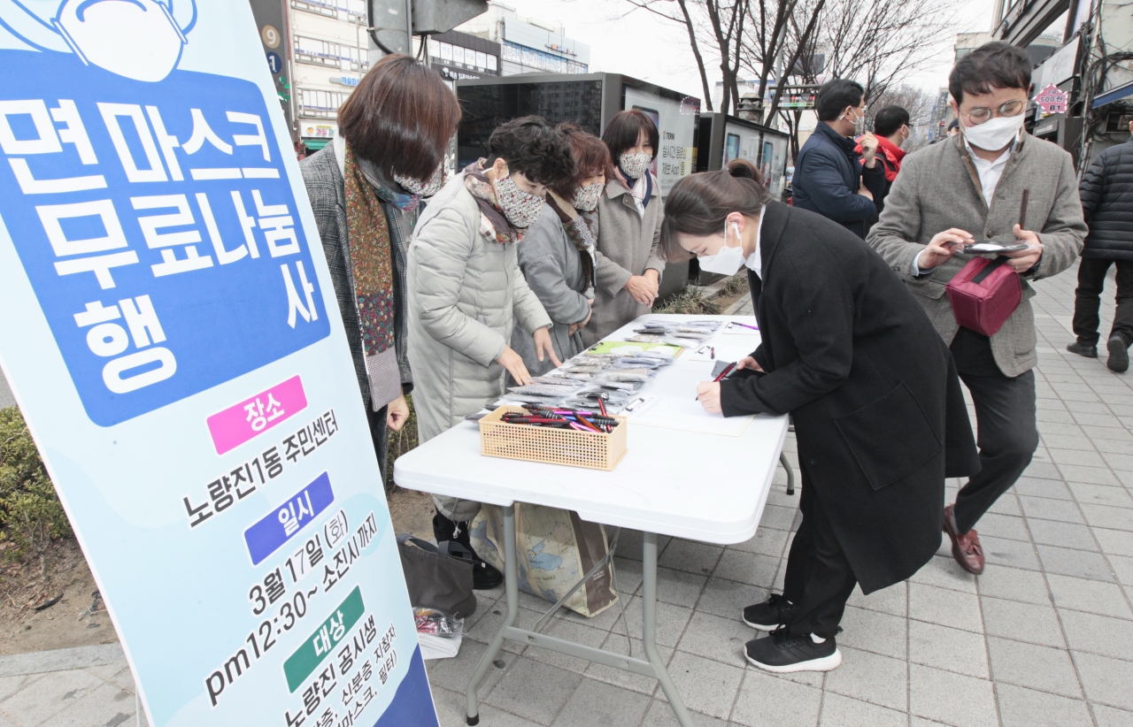 지난 17일 동그리마을넷에서 코로나19 지역사회 확산 차단을 위해 면마스크를 노량진학원가에서 학원생 등 청년들에게 무료로 배부하고 있다. [동작구 제공]