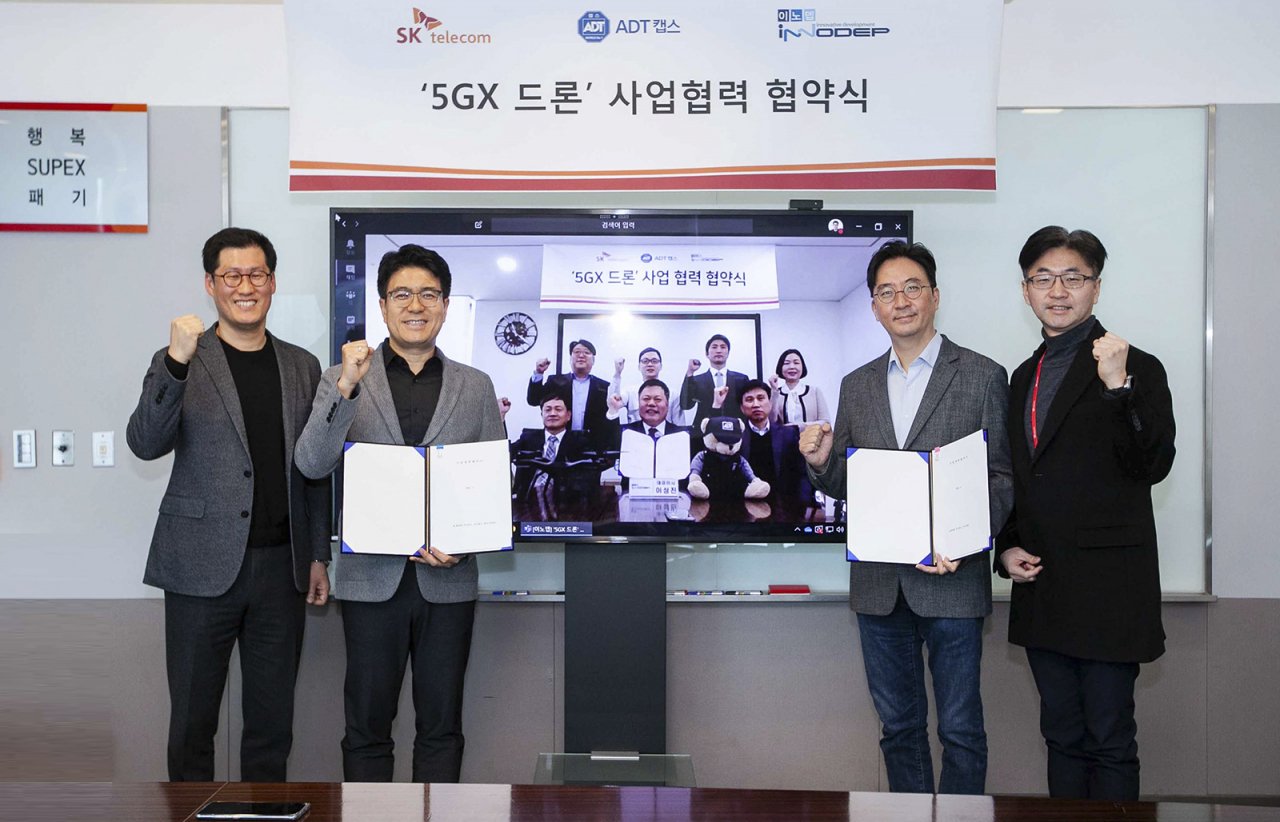 지난 18일 SK텔레콤과 ADT캡스, 이노뎁 등 3사는 5G 산업용 드론 사업화를 위한 협약식을 영상통화로 진행했다고 밝혔다. 박진효 SK텔레콤 보안사업부장(ADT캡스 대표 겸임)과 김윤 CTO(오른쪽서 2번째), 이성진 이노뎁 이성진 대표(영상 속 앞줄 가운데) 등 관계자들이 기념사진을 찍고 있다. [SK텔레콤 제공]