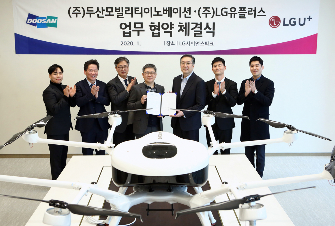 LG유플러스는 두산모빌리티이노베이션과 ‘드론 사업 확대를 위한 업무협약(MOU)’을 체결했다. 사진은업무협약 체결식에서 조원석 LG유플러스 기업신사업그룹장 전무(왼쪽에서 네번째)와 이두순 두산모빌리티이노베이션 대표(다섯번째) 등 참석자들이 기념 촬영하고 있는 모습. [LG유플러스 제공]