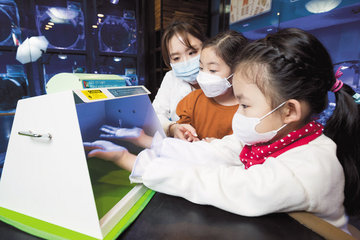 서울 송파구 롯데월드 아쿠아리움 해파리연구실에서 어린이들이 UV검사기로 손의 이물질을 확인하고 있다. [롯데월드 제공]