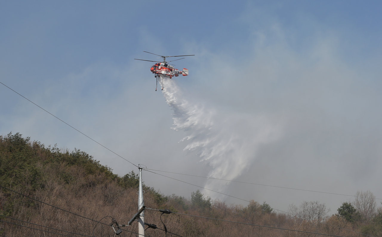 19일 오후 울산시 울주군 웅촌면 한 야산에서 불이 나 산림청 헬기가 물을 뿌리고 있다. [연합]