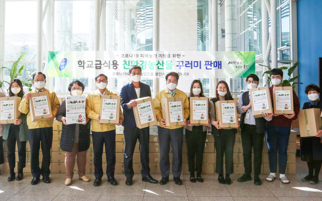백군기 시장이 직원들과 농산물 꾸러미를 들고 기념촬영을 하고 있다. [용인시 제공]