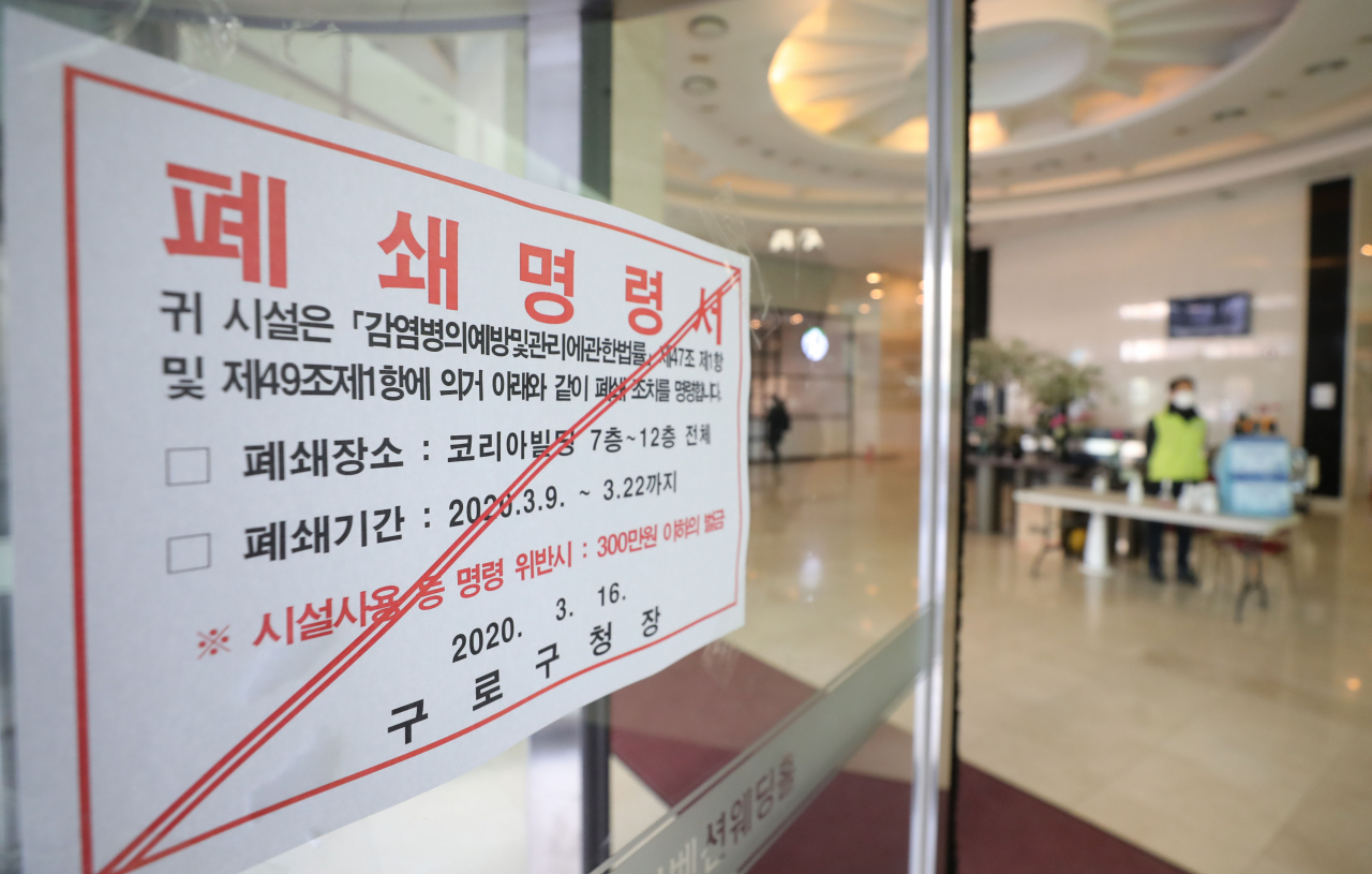 16일 오전 1층~6층에 대한 폐쇄 명령이 해제된 서울 구로구 코리아빌딩 입구에 콜센터에 해당되는 나머지 층에 대한 폐쇄 명령문이 붙어 있다. 코리아빌딩 7층부터 11층까지 위치한 콜센터에 신종코로나바이러스 감염증 확진자가 무더기로 발생함에 따라 지난 9일 구로구는 코리아빌딩 1&sim;12층에 대한 폐쇄 명령을 내린 바 있다. [연합]