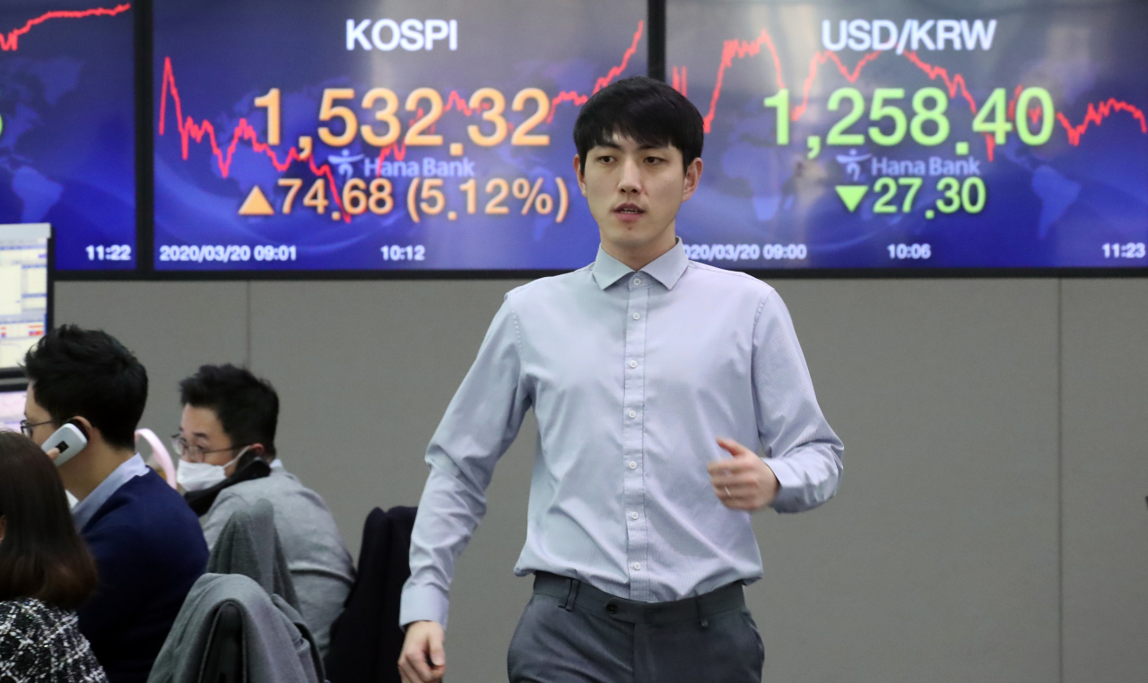 20일 서울 중구 하나은행 본점 딜링룸에서 한 외환 딜러가 증시 현황판 앞을 지나고 있다. 이날 코스피는 미 중앙은행인 연방준비제도의 통화스와프 협정 확대 등 시장 안정화 조치와 유럽 주요국 증시의 1~2%대 오름세 등 글로벌 증시의 반등에 힘입어 장중 1530선을 상회했다. 연합뉴스