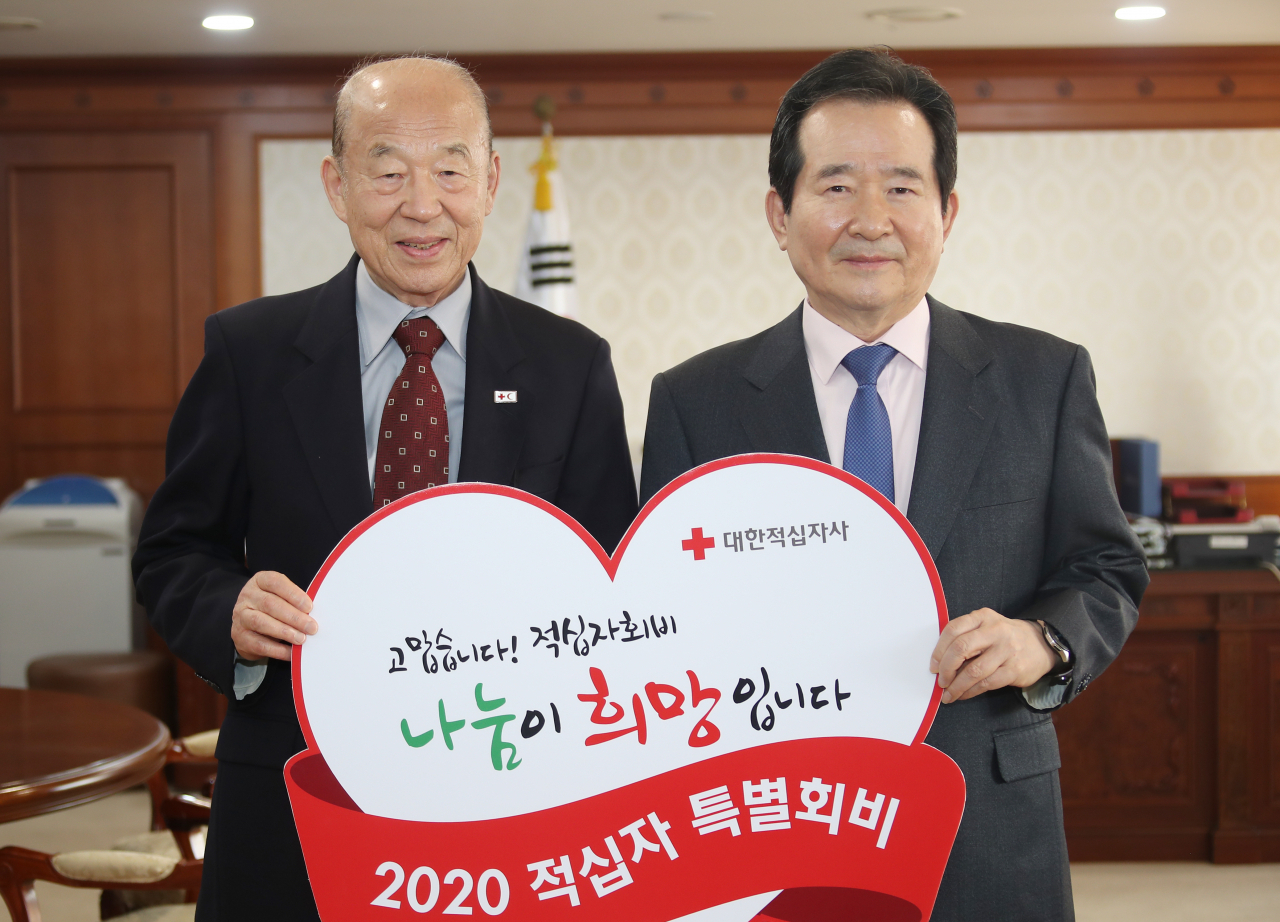 정세균 국무총리(오른쪽)가 20일 정부서울청사 집무실에서 박경서 대한적십자사 회장에게 적십자 특별회비를 전달하고 있다. [연합]