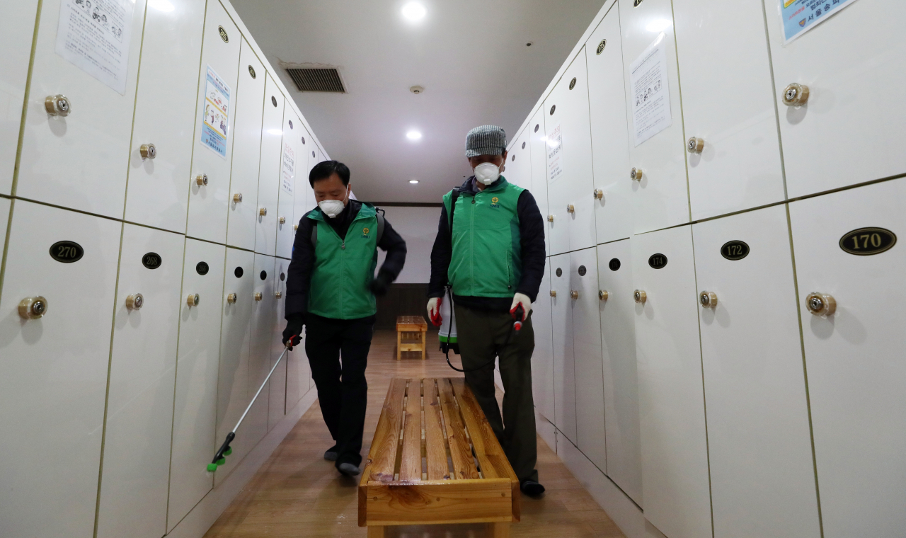 20일 서울 송파구청 관계자들이 관내 한 찜질방에서 코로나19 예방을 위한 방역을 하고 있다. [연합]