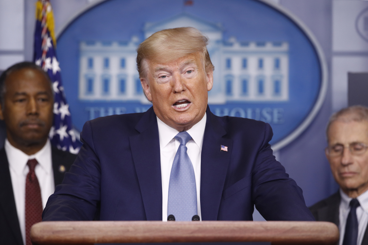 <YONHAP PHOTO-0169> President Donald Trump speaks during a coronavirus task force briefing at the White House, Saturday, March 21, 2020, in Washington. Housing and Urban Development Secretary Ben Carson, left, and Director of the National Institute of Allergy and Infectious Diseases Dr. Anthony Fauci listen. (AP Photo/Patrick Semansky)/2020-03-22 05:28:10/ <저작권자 ⓒ 1980-2020 ㈜연합뉴스. 무단 전재 재배포 금지.>