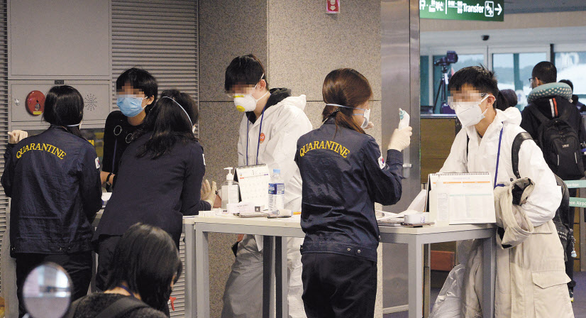 검역당국이 유럽발 전여행객들에 대해 코로나19전수검사를 시행하고 있는 가운데 23일 오전 인천국제공항 1터미널 도착층의 선별진료소에서 런던발 항공기를 이용해 입국한 유증상자들이 검역관과 이야기를 하고 있다. [연합]