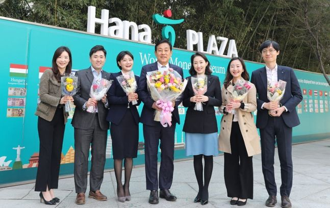 김정태 회장(왼쪽 네번째가운데)이 23일 하나금융그룹 명동 사옥에서 직원들에게 꽃을 선물하고 기념촬영을 하고 있다. [사진=하나금융그룹]