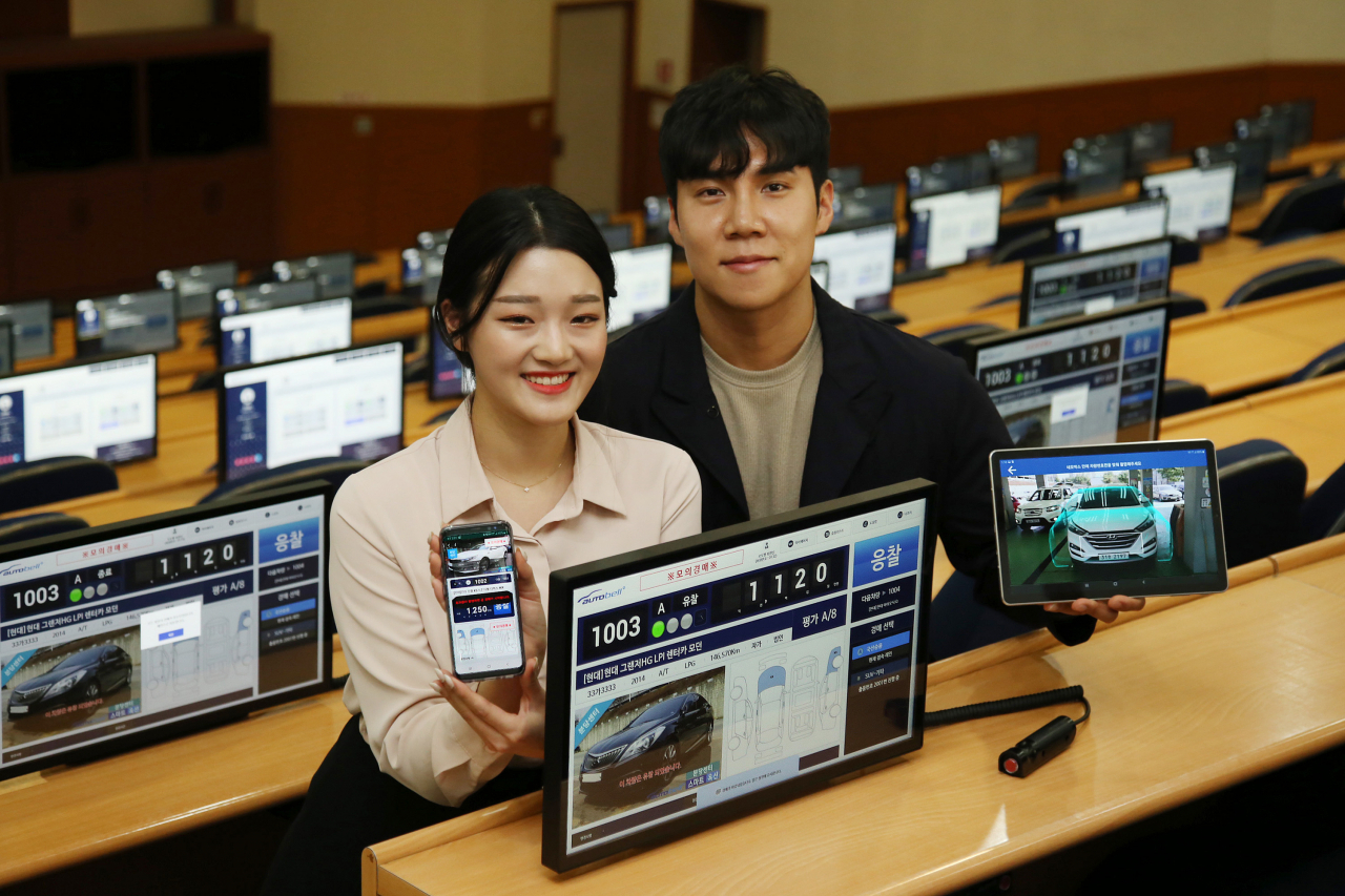 현대글로비스 직원들이 24일 분당 자동차 경매장에서 모바일 기기를 이용해 클라우드 경매 시스템 '오토벨 스마트옥션'을 시현하고 있다. [현대글로비스 제공]