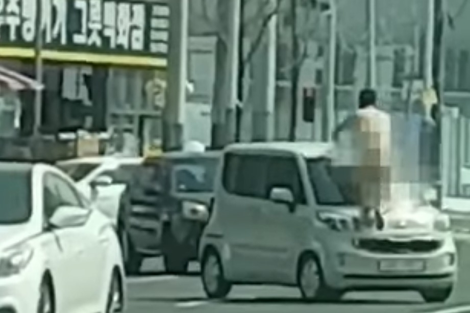 지난 22일 오전 11시30분께 울산시 남구 삼산동 농수산물도매시장 앞 도로에서 30대 A씨가 나체로 차량에 올라타 폭력을 행사하고 있다. [온라인 커뮤니티]