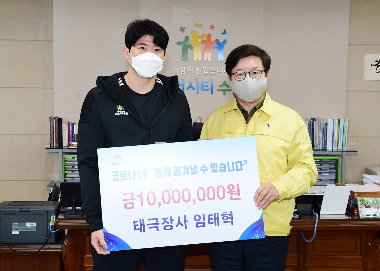 임태혁 씨름선수(왼쪽)가 염태영 수원시장(오른쪽)에게 기부금 1000만 원을 전달한 후 함께하고 있다. [수원시 제공]
